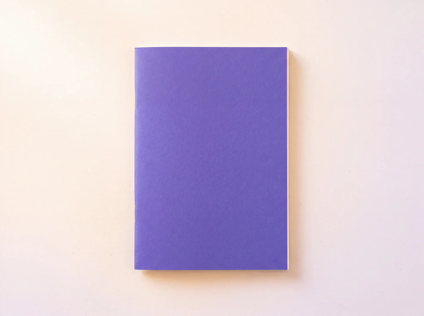 Livret violet posé sur une table claire, avec son titre ajouté dans la page